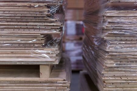 Timber Flooring Factory. Pile of cut wood in factory storage warehouse. Lumber in warehouse.の写真素材