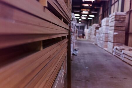Timber Flooring Factory. Pile of cut wood in factory storage warehouse. Lumber in warehouse.の写真素材