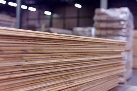 Timber Flooring Factory. Pile of cut wood in factory storage warehouse. Lumber in warehouse.の写真素材