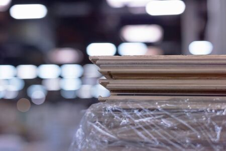 Timber Flooring Factory. Pile of cut wood in factory storage warehouse. Lumber in warehouse.