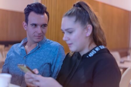 Two Young Business People Gathered Together Discussing Creative Idea Cafe.Startup Concept Coworkers...