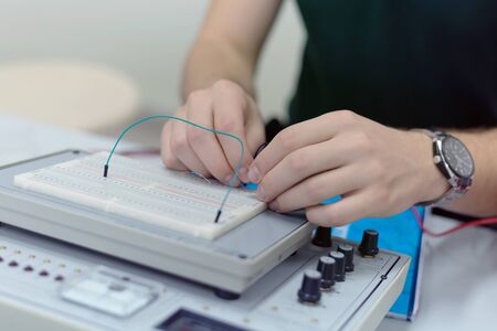 Engineering students working in the lab. Students are adjusting an electrical's components inside lab.の写真素材