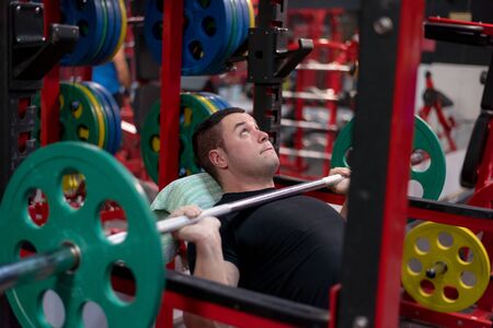 Hard Core Bodybuilding. Muscular athletic bodybuilder fitness model training arms with dumbbells in...