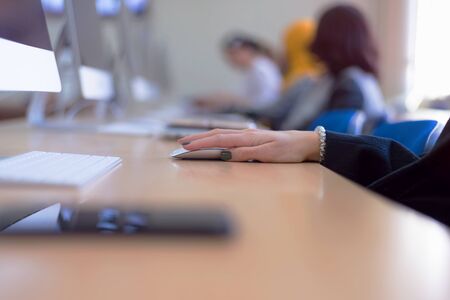 Group of  university IT technologies students working on practice lessons. Sitting near therir...