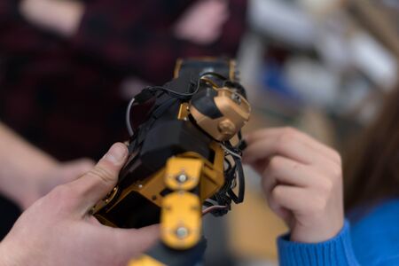 Group of young engineers working on robotics project. Scientist engineers designing small human robot, setting artificial intelligence humanoid robot.の写真素材