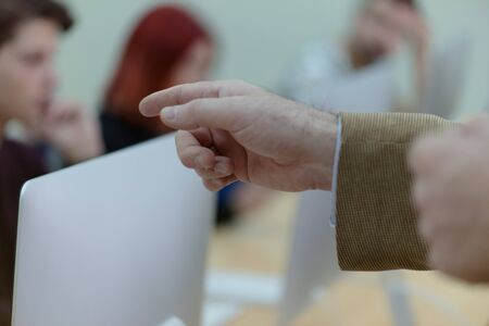 IT technologies teacher at work. IT professor explain lesson to multietchnic students. Professor's hand with gesture.の写真素材