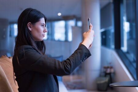 Beautiful black haired Businesswoman posing and shooting selfie inside co work space in the...