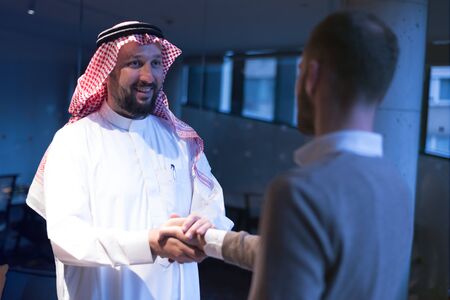 Arab Businessmen's Handshake with American Businessman Descent. Confirmation of Business alliance Partners as WELL. Adhering Respect, Commitment and Integrity in Business Partnership Dealの写真素材