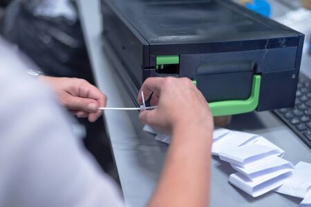 Finance person organizing large number of banknotes at the center for cash services.