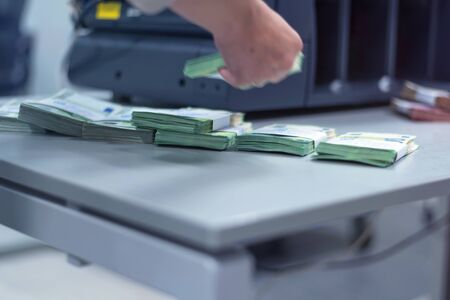 Bank employees sorting and counting money inside bank vault. Large amounts of money in the bank.の写真素材