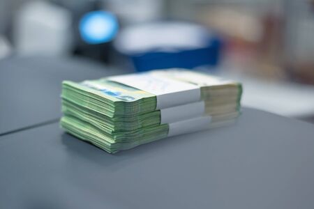 Bank employees sorting and counting money inside bank vault. Large amounts of money in the bank.