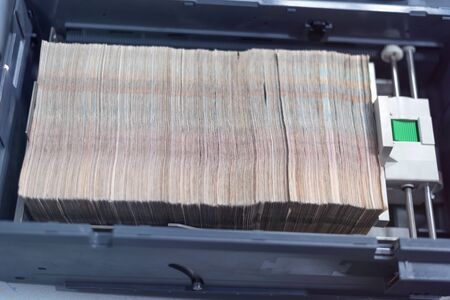Carton boxes filled with sorted money and stored in a cage in the treasury department.
