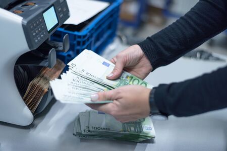 Bank employees sorting and counting money inside bank vault. Large amounts of money in the bank.の写真素材