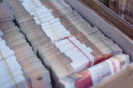 Carton boxes filled with sorted money and stored in a cage in the treasury department.