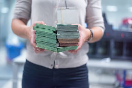 Finance person organizing large number of banknotes at the center for cash services.Finance person counting euro â¬ bills after they are counted on the counting machine.の写真素材
