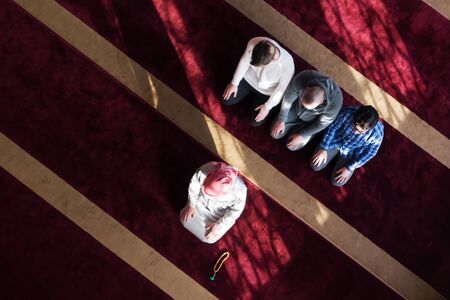 Group of young Muslim people praying. Muslim prayers doing a pray inside the mosque.の写真素材
