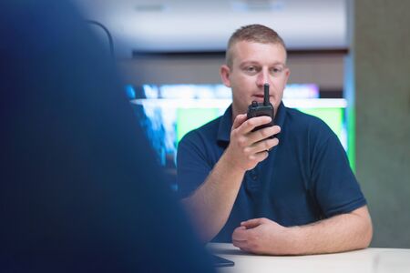 Security guard monitoring modern CCTV cameras in surveillance room.  Male security guard in surveillance room.の写真素材