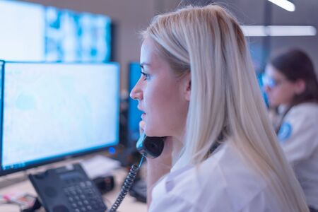 Security guard monitoring modern CCTV cameras in surveillance room. Female security guard in surveillance room.の写真素材