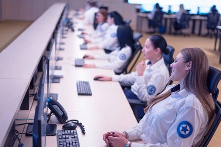 Group of security guards working on computers while sitting in the main control room, CCTV surveillance.の写真素材