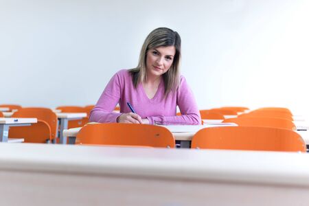 Young femaleeconomy student analyzing company annual financial report balance and prepairing for test. Concept of economy, education.の写真素材