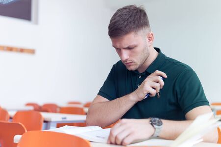 Young male economy student analyzing company annual financial report balance and prepairing for...
