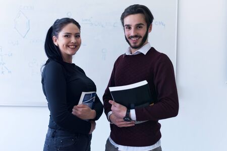 Two young female and male economy students analyzing company annual financial report balance and prepairing for test. Concept of economy, education. market.の写真素材
