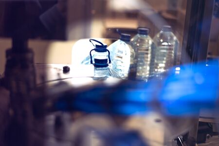 Bottling plant - Water bottling line for processing and bottling pure spring water into blue bottles. Selective focus.の写真素材
