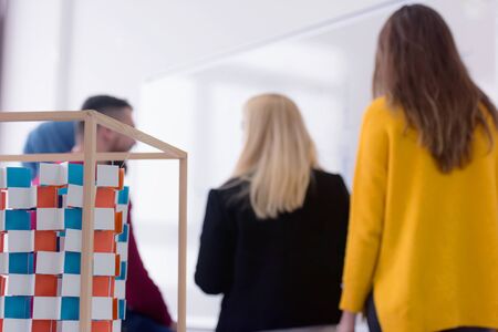 Female Architecture teacher at work. Female professor explain architectural projects to students. Beautiful female university architecture professor explain lessons to multiethnic students.の写真素材