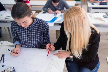 Female Architecture teacher at work. Female professor explain architectural projects to students....
