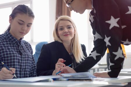 Female Architecture teacher at work. Female professor explain architectural projects to students. Beautiful female university architecture professor smiling into camera.の写真素材