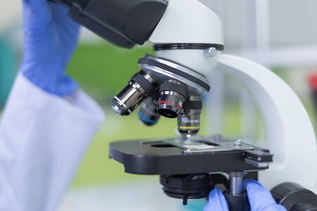 Young female Laboratory scientist working at lab with test tubes and microscope, test or research in clinical laboratory.Science, chemistry, biology, medicine and people concept.の写真素材