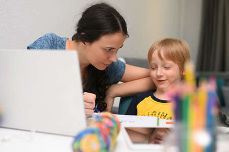 Online courses for preschoolers. 5 years boy uses a laptop at home. Homework with his mother in...