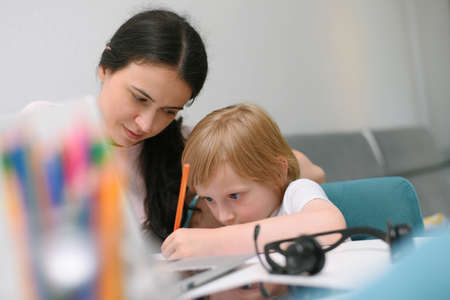 Online courses for preschoolers. 5 years boy uses a laptop at home. Homework with his mother in quarantine at home during covid 19 coronavirus pandemic.の写真素材