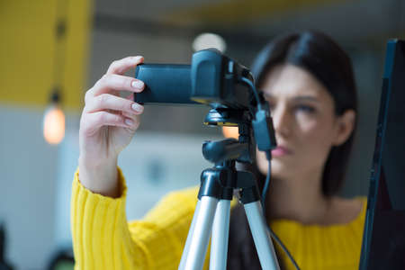 Attractive female blogger recording video for vlog. Gorgeous female coach and blogger giving antistress advice to her followers on video.の写真素材