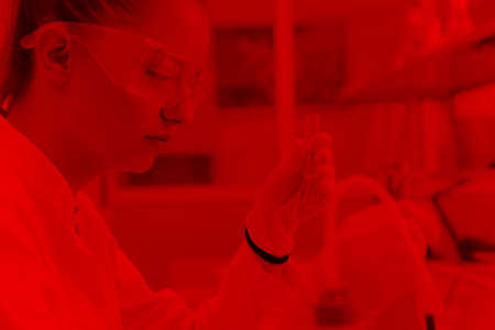 Young female scientist doing experiments in laboratory