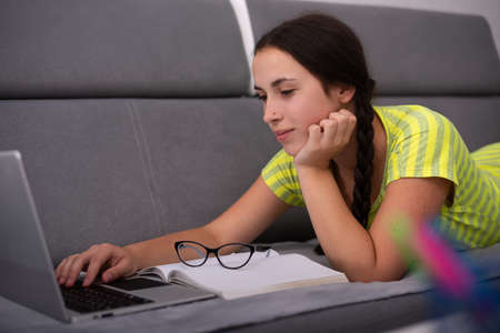 Social distancing student concept, education at home. High school girl doing homework at home with...