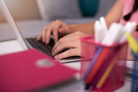 Social distancing student concept, education at home. High school girl doing homework at home with laptop. Teen study home the school is closed during Coronavirus Covid-19.の写真素材