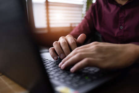 Young black male  developer sitting in pizza restaurant, drinking coffee or  tea and working with...