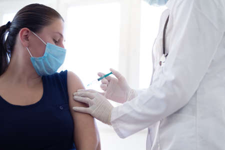 Close up of a Doctor making a vaccination in the shoulder of patient, Flu Vaccination Injection on Armの写真素材