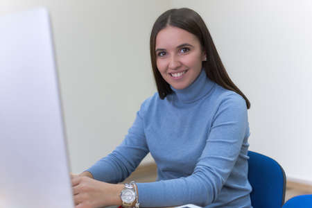 Beautiful female  IT student working at her computer lab.  Female student listening lesson from...