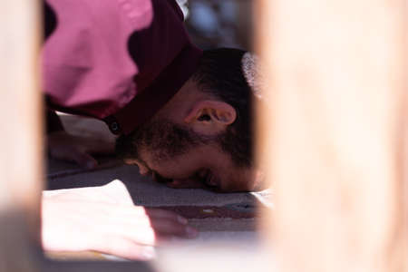 African Muslim Man Making Traditional Prayer To God. Religious black muslim man praying inside the mosque during ramadanの写真素材