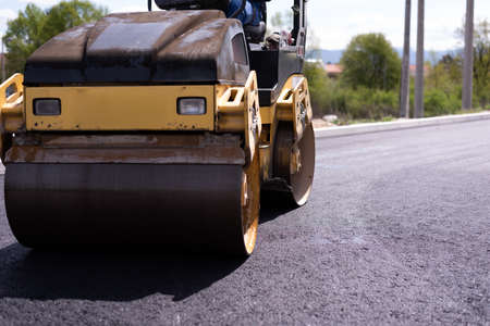 Urban road asphalting works. Asphalt paving. Paver machine and road roller. New road construction.の写真素材