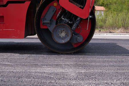 Urban road asphalting works. Asphalt paving. Paver machine and road roller. New road construction.