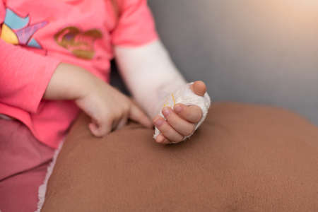 Girl's broken left arm has drawn a cute image on her arm on the plasterの写真素材