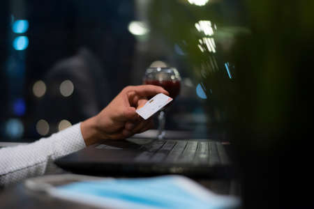 Successful black businessman holding plastic card making transaction using mobile banking...
