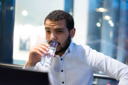 Virtual meeting with many people together. African-American young guy talking online with employees via video connectionの写真素材