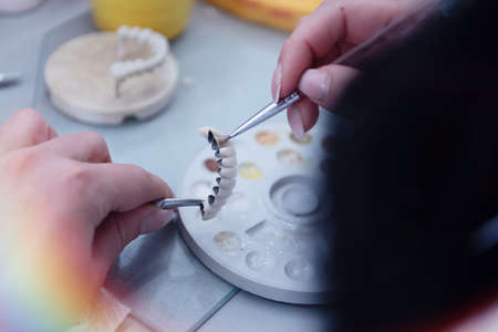 Dental prosthesis, dentures, prosthetics work. A study and a table with dental toolsの写真素材