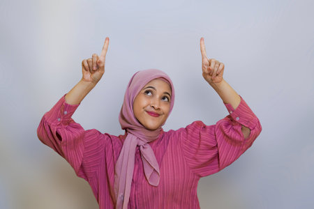 Cheerful muslim woman happy presenting and pointing. using hand to presenting something concept