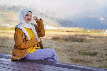 Pretty woman doing love sign, vacation concept for muslim womanの写真素材