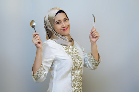 Indonesian muslim woman excitedly waiting for food after long day fasting diet during ramadanの写真素材